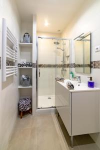een witte badkamer met een douche en een wastafel bij Le Sémaphore in Saint-Raphaël