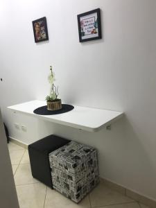 a white table with a plant on top of it at Hotel Cavalinho Branco - Apartamento 516 in Águas de Lindoia