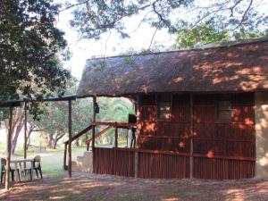 a small building with a thatched roof and a bench at Kosi Bay Casitas in Manguzi