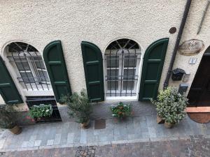 four green doors and potted plants on a building at MentoreR&B in Noceto