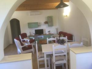 a dining room with white chairs and tables and a computer at Casa Victor in Playa Migjorn +11 photos