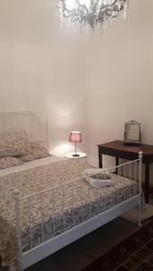 ein Schlafzimmer mit einem Bett und einem Tisch mit einer Lampe in der Unterkunft Carrubo - Giardino in città in Catania
