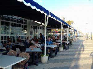 un grupo de personas sentadas en mesas en un restaurante en Piso Rubarsal, en Torrox Costa