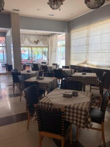 jadalnia ze stołami, krzesłami i oknami w obiekcie Hotel Kypreos w mieście Kamena Wurla
