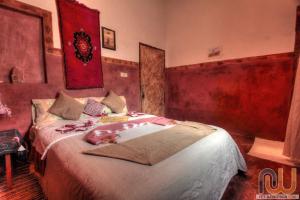 a bedroom with a bed with a person laying on it at Guest housse Kasbah tifaoute in Aït Benhaddou