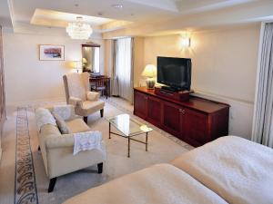 een woonkamer met een bank en een televisie bij Bandai Silver Hotel in Niigata