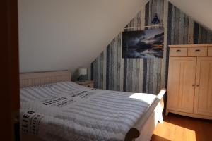 a bedroom with a bed and a wooden wall at Ferienhaus Blomengoorn in Boltenhagen