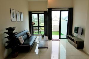 a living room with a black couch and a television at SL TR Homstay in Cameron Highlands