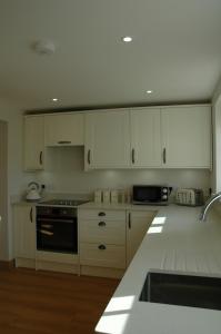 a kitchen with white cabinets and a stove top oven at The Winning Post, Bruton in Bruton