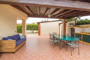 a patio with a table and chairs and a couch at Casa Samoa - Siracusa, fronte mare in Siracusa