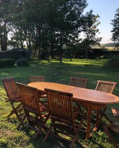 una mesa de madera con 4 sillas alrededor en Maison familiale au calme/5 chambres/Grand jardin en Bangor