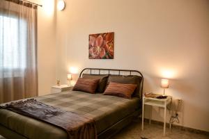 una camera con un letto con due comodini e due lampade di Casa Pomelia a Castellammare del Golfo