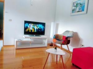 a living room with a tv and a chair at Apartmani Pavla in Orebić