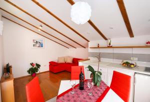 a kitchen with red chairs and a red couch at Apartmani Pavla in Orebić