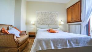 a bedroom with a white bed and a chair at Ravello View in Scala