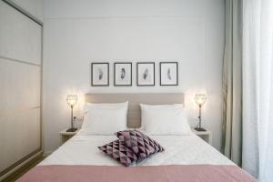 a white bed with two pillows and two lamps at CasAlma I in Plános