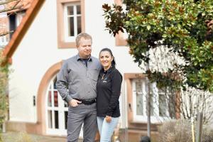 un homme et une femme debout devant une maison dans l'établissement Chalet Raabe, à Sankt Martin