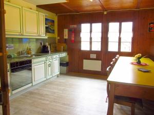 uma cozinha com armários amarelos e uma mesa em Baracca Backpacker em Aurigeno