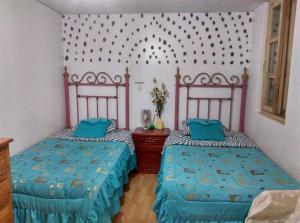 1 dormitorio con 2 camas y edredones azules en Escocie - Centro Historico, en Quito