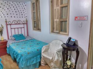 a bedroom with a bed and a phone on a table at Escocie - Centro Historico in Quito