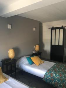 a bedroom with two beds and two lamps on the wall at Hôtel Le Mistral in Marseille