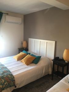 a bedroom with a bed with two pillows and a window at Hôtel Le Mistral in Marseille