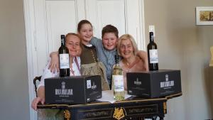 a group of people posing for a picture with wine bottles at Feine Herbergen Maria Magdelena in Bad Aussee