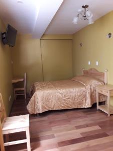 una camera con letto, TV e tavolo di Hostal Cactus a Cuzco