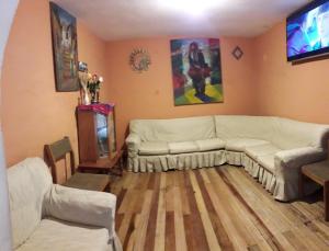 a living room with a white couch and a tv at Hostal Cactus in Cusco