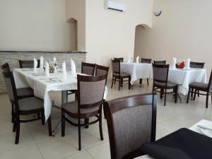 a dining room with white tables and chairs at Wadonda Suites in Zomba