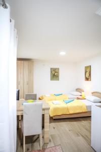 1 Schlafzimmer mit 2 Betten, einem Tisch und Stühlen in der Unterkunft Studio Kaća in Cetinje