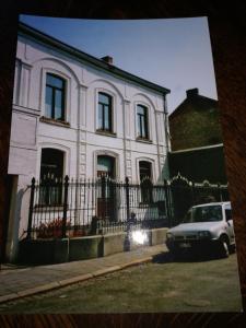 a white house with a car parked in front of it at B and B Comme chez soi in La Hestre