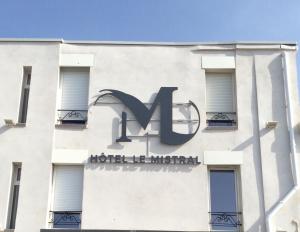 a building with a sign on the side of it at Hôtel Le Mistral in Marseille
