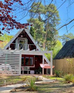 una pequeña casa con techo blanco en Nadi's Holiday Home – Heart of Woods, Szentendre Island en Szigetmonostor