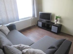 a living room with a couch and a tv at Family Apartment in Rīga