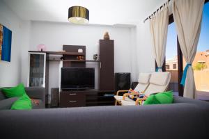 sala de estar con sofá y TV en La Casa Sahi en Gáldar
