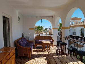 ein Wohnzimmer mit Bögen, einem Tisch und Stühlen in der Unterkunft Дуплекс " Torre Gala" Playa Flamenca in Playa Flamenca