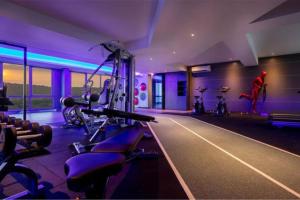 Un gimnasio con máquinas de cardio y una persona al fondo. en SKY POOL Stylish Suite 2-7Pax at KL City, en Kuala Lumpur