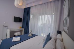 um quarto com uma cama e uma grande janela em Akti Alegra In Front The Beach em Neos Marmaras