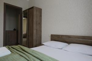 una camera da letto con un letto e uno specchio di Ia's Guest House a Kazbegi