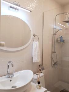 a bathroom with a sink and a shower with a mirror at Karin House in Tbilisi City