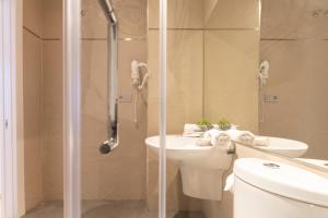 y baño con ducha, aseo y lavamanos. en San Jerónimo 17 Suites en Granada