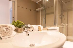 y baño con lavabo blanco y espejo. en San Jerónimo 17 Suites en Granada