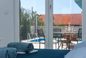a room with a bed and a balcony with a pool at Villa Dodo in Makarska