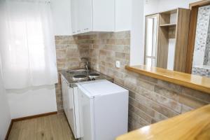 a small kitchen with a sink and a white refrigerator at Apartman Kaća in Cetinje