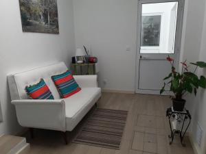 a living room with a white couch and a window at Pés Verdes-Alojamento e Chá in Ponta Delgada