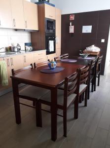 a kitchen with a wooden table and chairs in a kitchen at Pés Verdes-Alojamento e Chá in Ponta Delgada