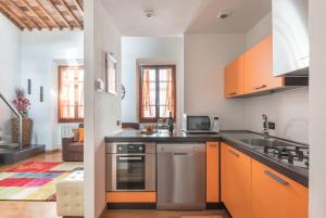 - une cuisine avec des armoires orange et un évier dans l'établissement Casine 28 apartment, à Florence