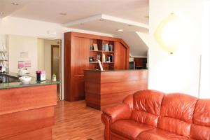 a living room with a leather couch and a counter at Hotel Santa Lucia in Bastia Umbra