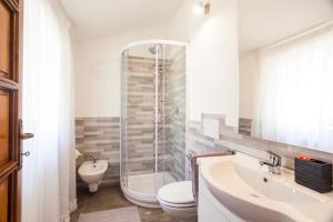 a bathroom with a shower and a toilet and a sink at Tony Home in Olbia